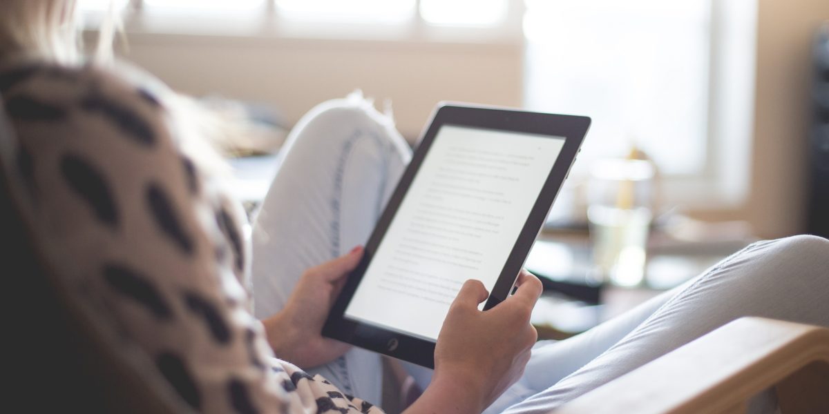 Woman reading on an Amazon Kindle